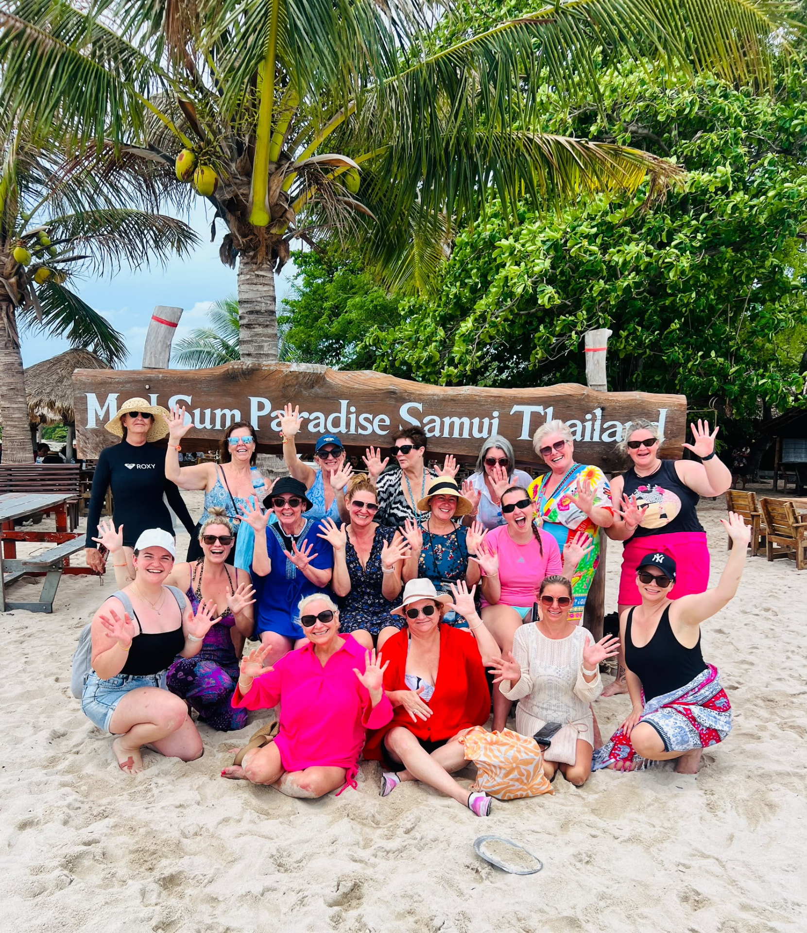 Retreat ladies waving under the Koh Samui beach sign